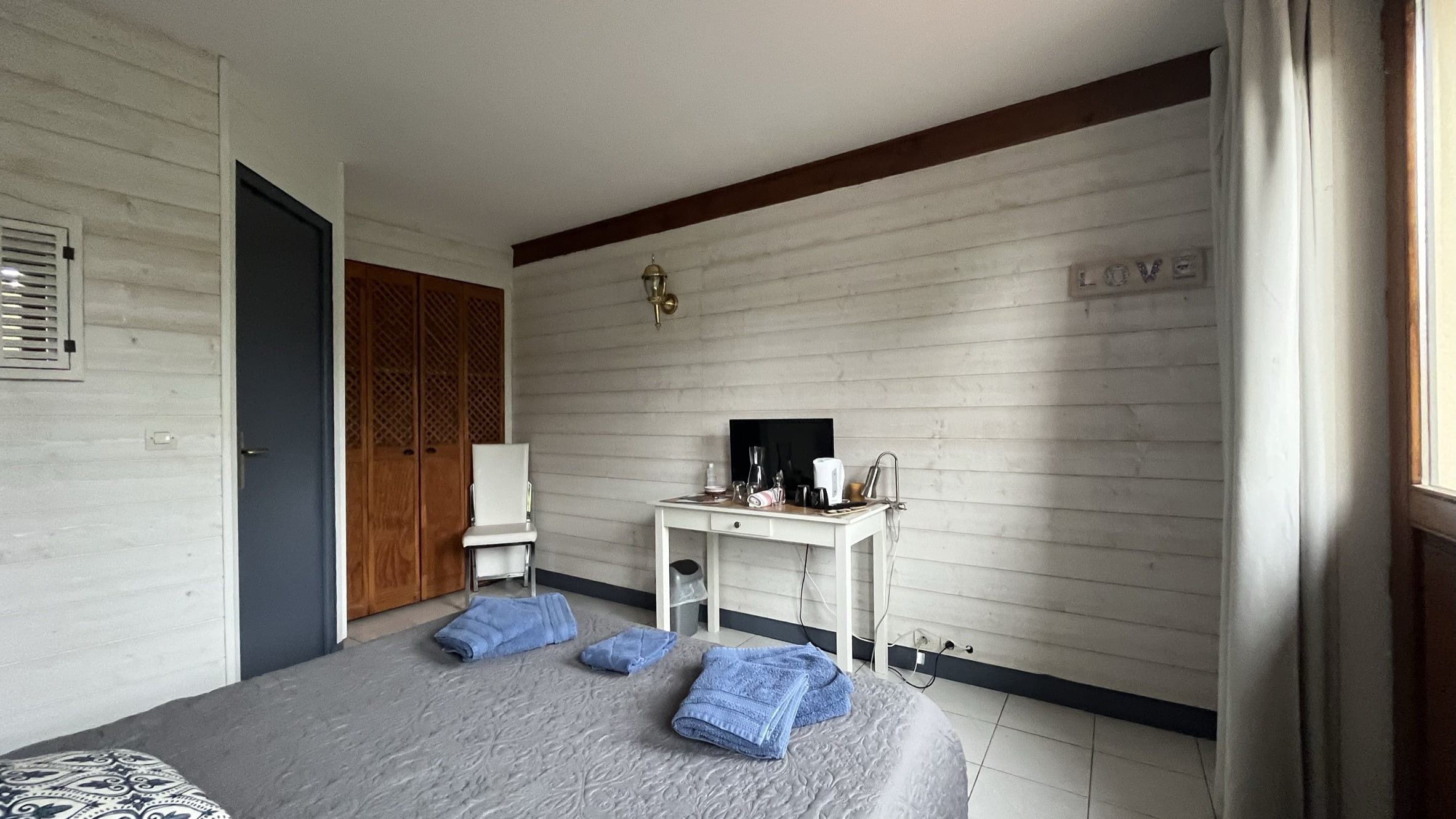 Chambre Fort-Mahon avec vue sur le lit double, un meuble tv et la tv écran plat.