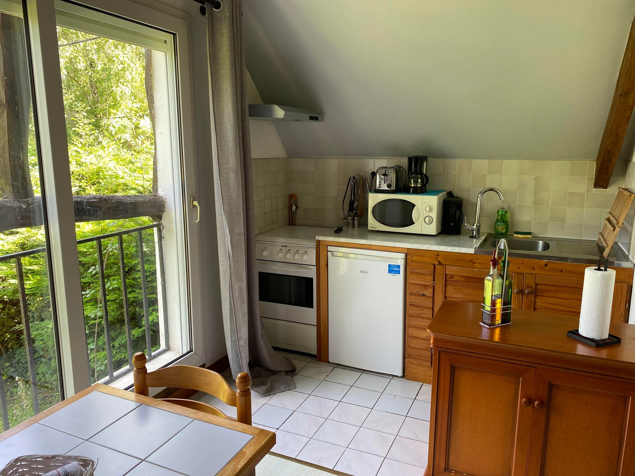Coin cuisine du gîte n°8 Rue, avec une cuisine équipée : évier, micro-ondes, cafetière, grille-pain et un frigo.